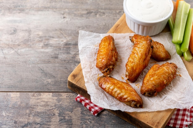 asas de frango picantes de búfalo com molho de pimenta caiena em uma mesa de madeira