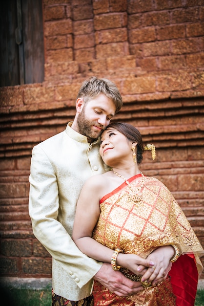 Asiática noiva e caucasiano noivo tem tempo romântico com vestido de tailândia