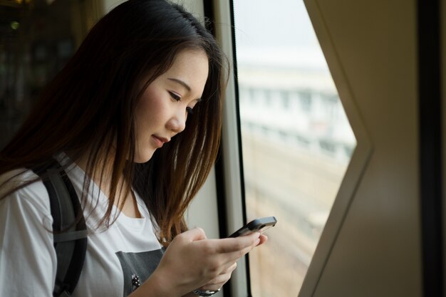 Asiático, mulher, turista, usando, smartphone, enquanto, viagem