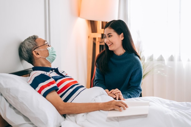 Asiáticos no quarto do paciente no hospitalcaregiver e homem mais velho conversando juntos após o check-up de saúde