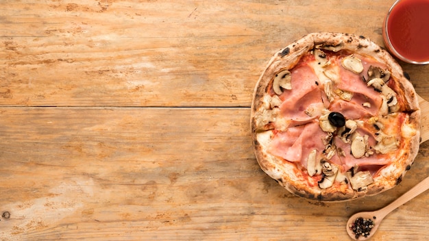 Assado de cogumelos e bacon pizza com molho de tomate sobre a mesa de madeira velha