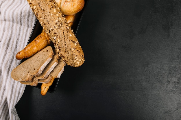 Foto grátis assado pães integrais com guardanapo na bancada da cozinha preto