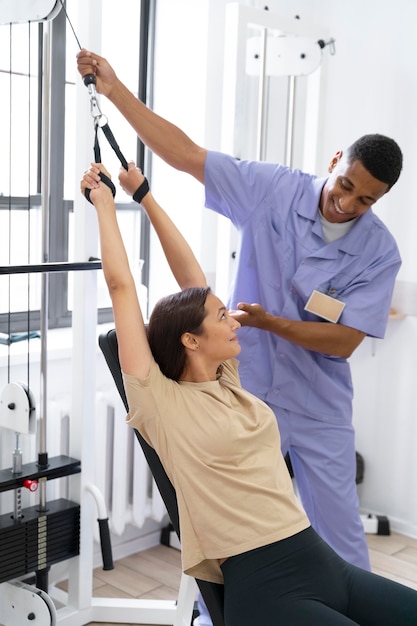 Assistente médico ajudando paciente com exercícios de fisioterapia