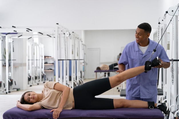 Assistente médico ajudando paciente com exercícios de fisioterapia