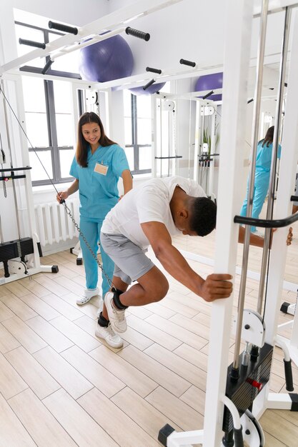 Assistente médico ajudando paciente com exercícios de fisioterapia