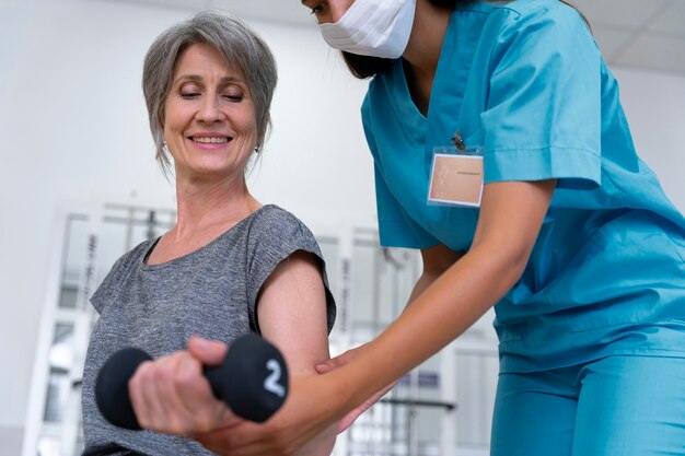 Assistente médico ajudando paciente com exercícios de fisioterapia