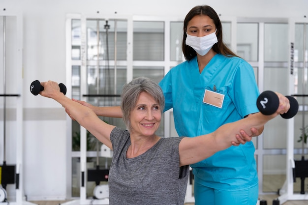 Assistente médico ajudando paciente com exercícios de fisioterapia