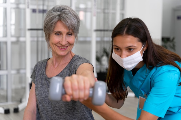 Assistente médico ajudando paciente com exercícios de fisioterapia