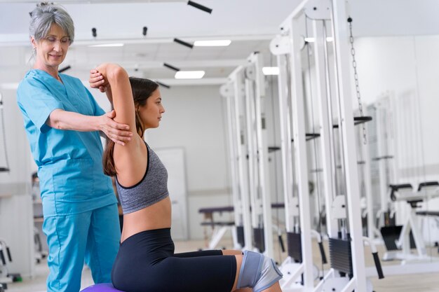 Assistente médico ajudando paciente com exercícios de fisioterapia