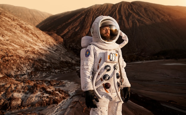 Astronauta masculino olhando para o sol durante uma missão espacial em outro planeta