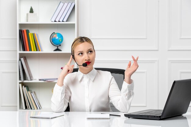 Atendimento ao cliente linda loira de camisa branca com laptop e fone de ouvido olhando confusamente