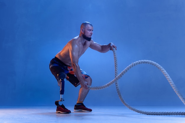 Atleta com deficiência ou amputado isolado na parede azul.