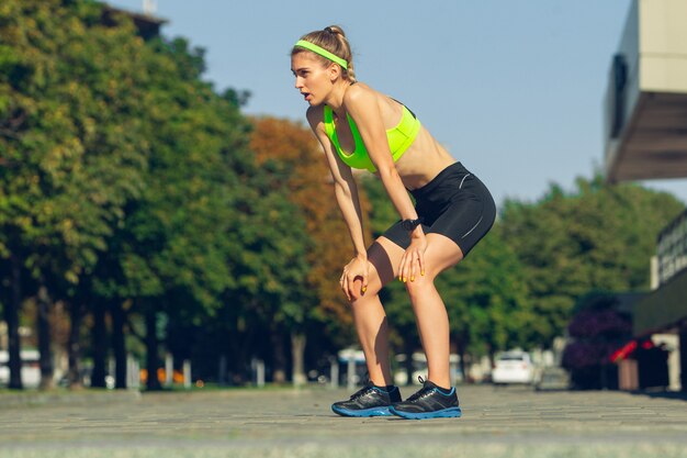 Atleta corredora treinando ao ar livre em dia ensolarado de verão