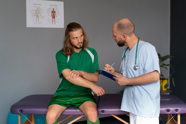 Atleta de vista frontal conversando com fisioterapeuta