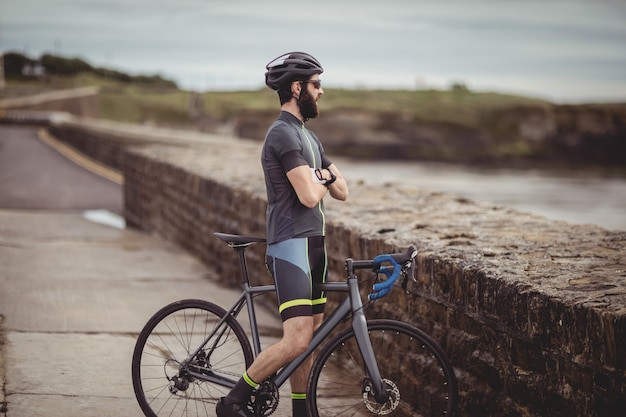 Atleta em pé com sua bicicleta