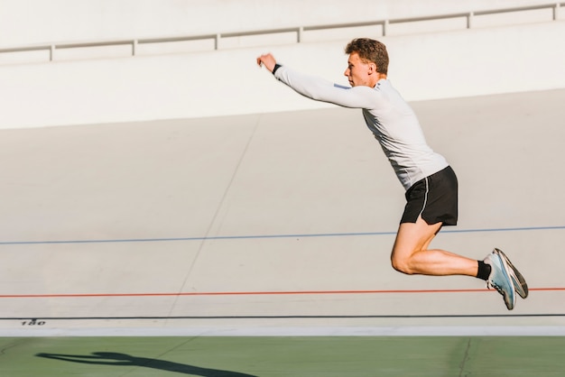 Atleta fazendo um salto em comprimento com espaço de cópia