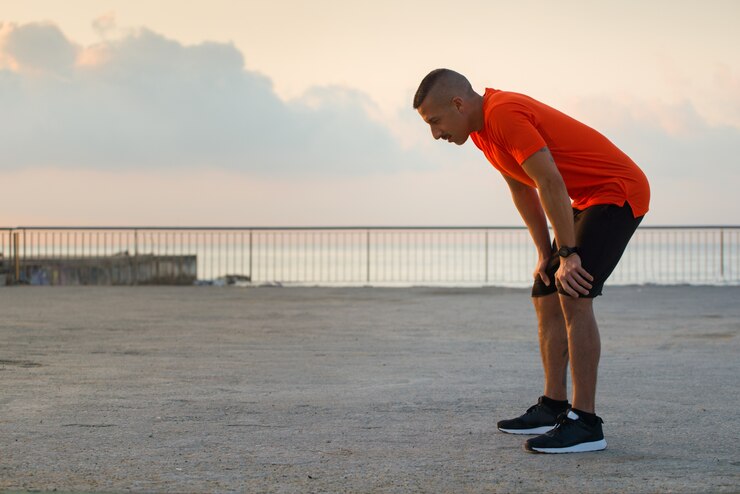 Foto grátis atleta macho cansado tendo uma ruptura depois de correr
