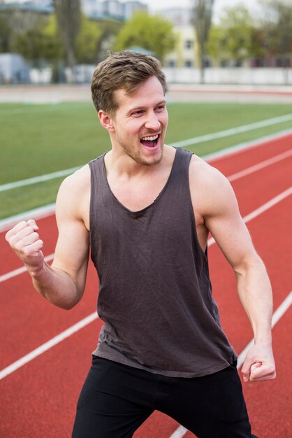 Atleta masculino, comemorando sua vitória na pista de corrida