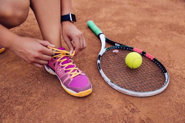 Foto grátis atleta mulher se preparando para jogar uma partida de tênis, amarrando cadarços.