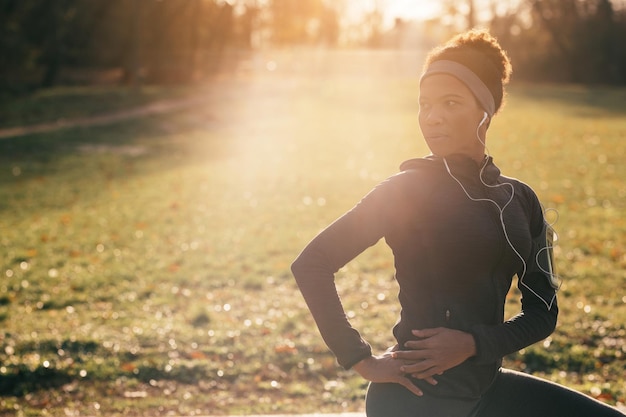 Atleta negra se aquecendo e se preparando para treinamento esportivo na natureza copie o espaço