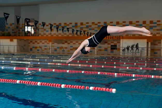 Atleta pulando na piscina tacada completa