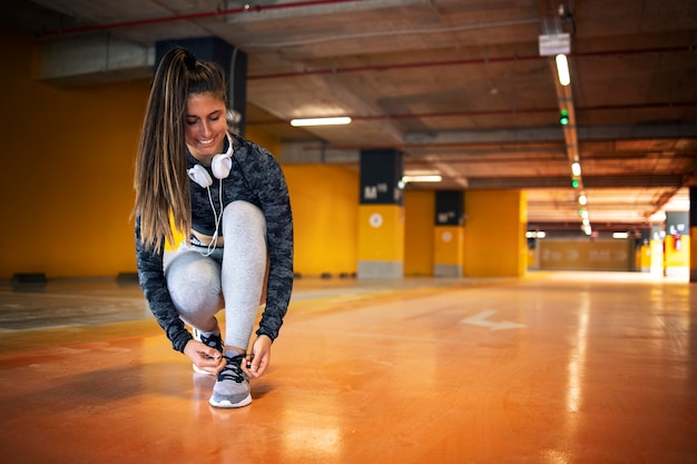 Atleta sorridente, amarrando o cadarço e se preparando para o treinamento