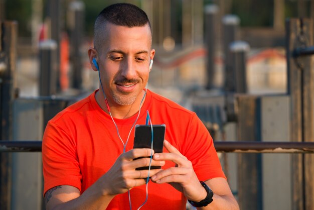 Atleta sorrindo baixando músicas para smartphone