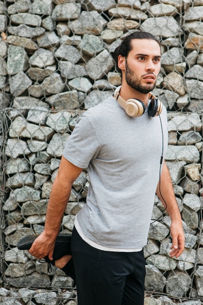 Atleta urbana ao lado da parede de pedra