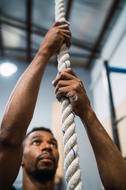 Atlético homem fazendo exercício de escalada.