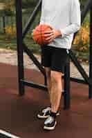 Foto grátis atlético homem segurando basquete