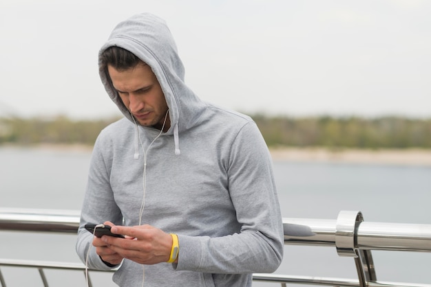 Foto grátis atlético homem verificando seu telefone móvel