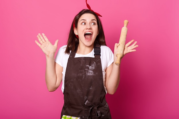 Atraente jovem beleza emocional gritando de alegria, levantando as mãos, olhando de lado, abrindo a boca amplamente