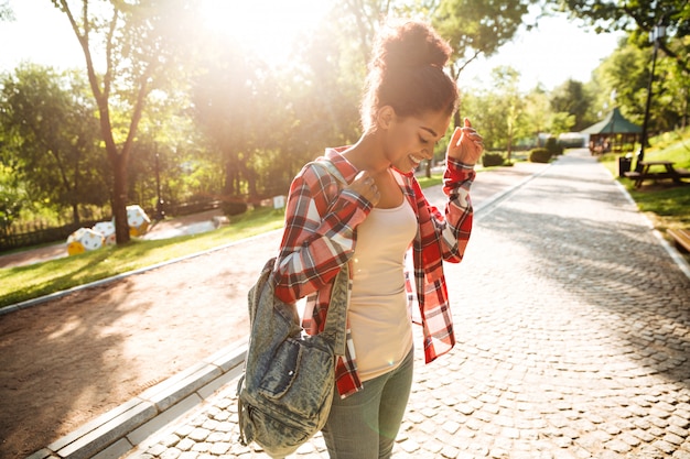 Foto grátis atraente jovem mulher africana caminhando ao ar livre