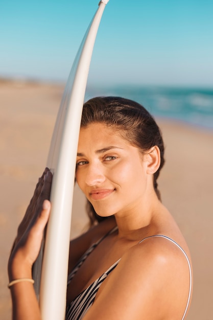 Atraente, mulher sorridente, segurando, surfboard, ligado, litoral