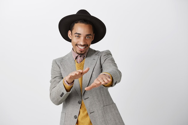 Foto grátis atrevido e bonito homem afro-americano de terno dançando e sorrindo feliz