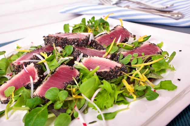 Atum grelhado com salada verde na mesa