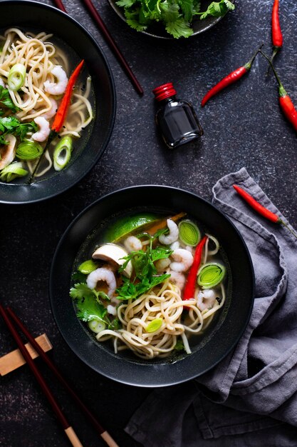 Autêntica sopa asiática de macarrão em tigela preta