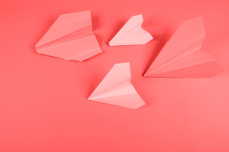 Foto grátis avião de papel coral e rosa em fundo colorido
