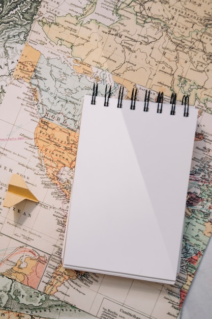 Foto grátis avião de papel e caderno close-up no mapa
