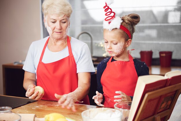 Avó e neta fazendo massa na cozinha