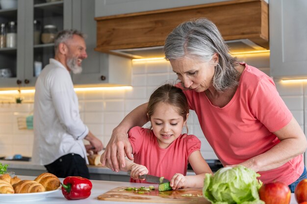 Avós de tiro médio e menina na cozinha