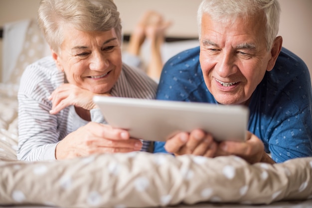 Foto grátis avós descansando enquanto usam um tablet digital