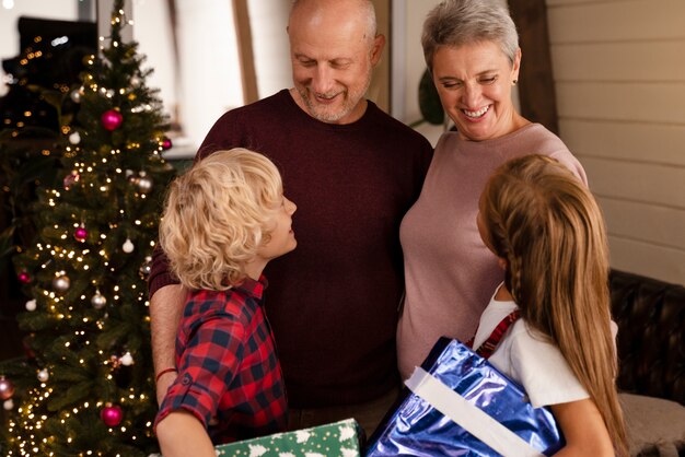 Avós e crianças abrindo presentes