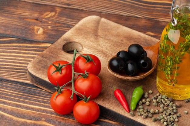 Azeite de oliva e tomate em fundo de madeira