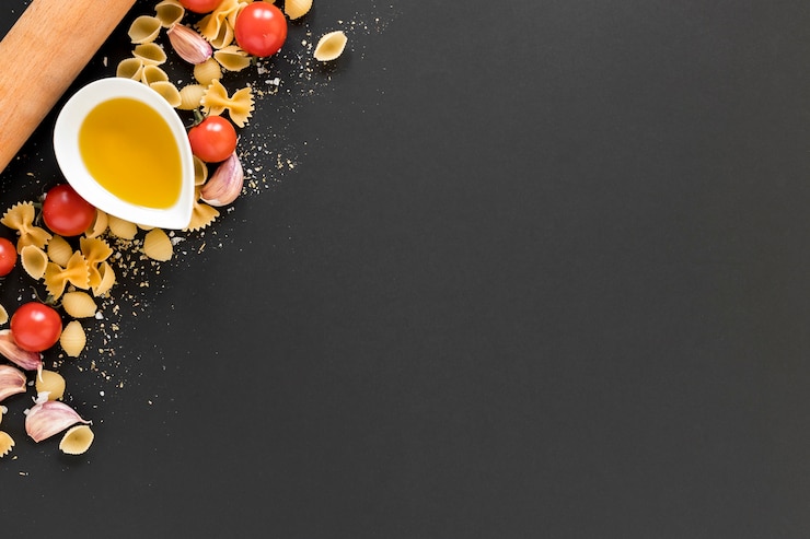 Foto grátis azeite; tomate cereja com massa italiana crua sobre o pano de fundo preto