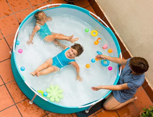 Baby-sitter feminino com garotas na piscina