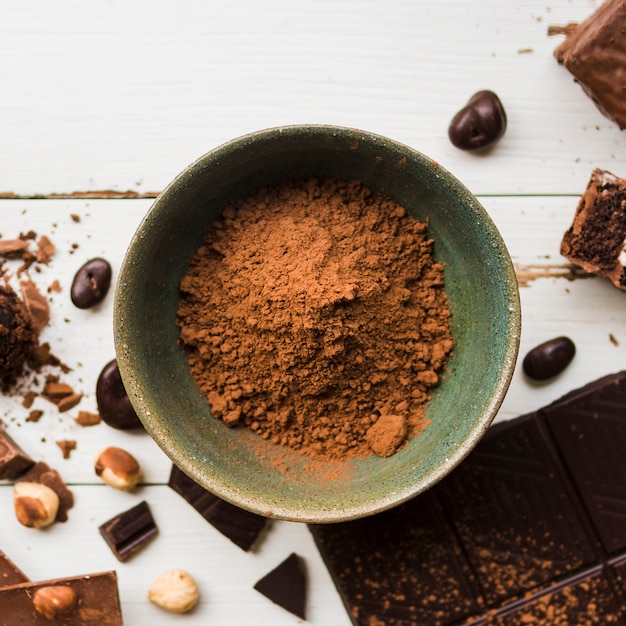 Bacia com cacau perto de doces de chocolate