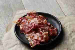 Foto grátis bacon frito em prato preto