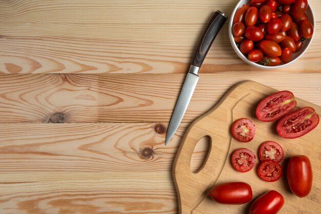 Bagas vermelhas e tomates fatiados na mesa de madeira