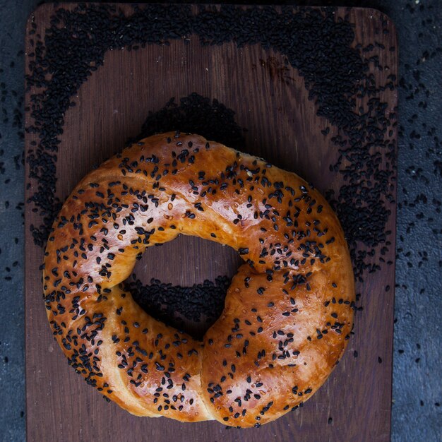 Bagel de vista superior com sementes de papoila na prancha de madeira